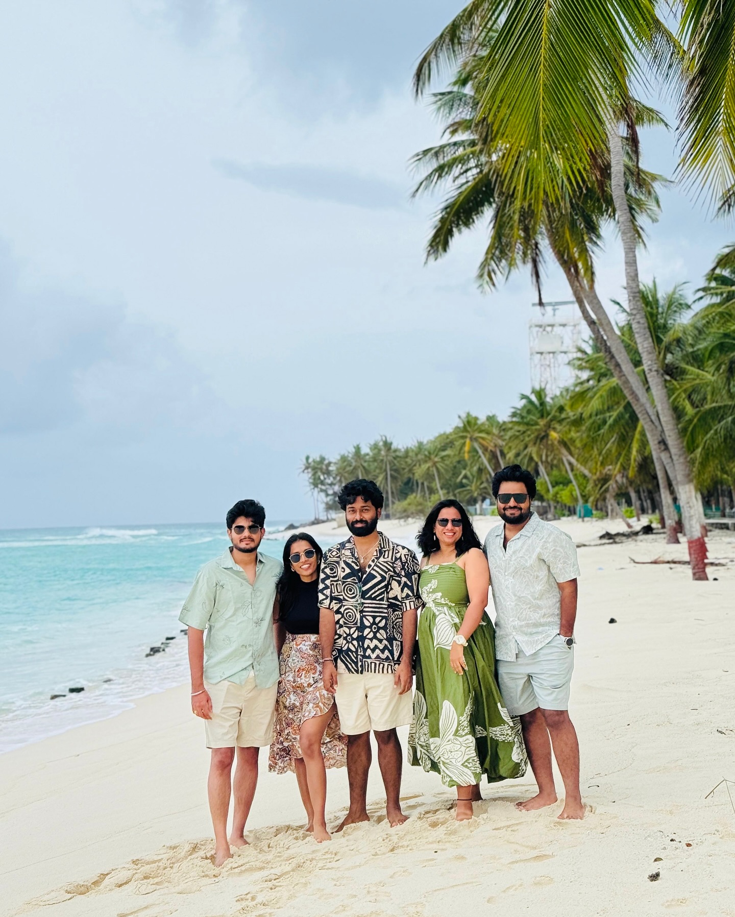 Group of friends posing on a white-sand Lakshadweep beach under palm trees